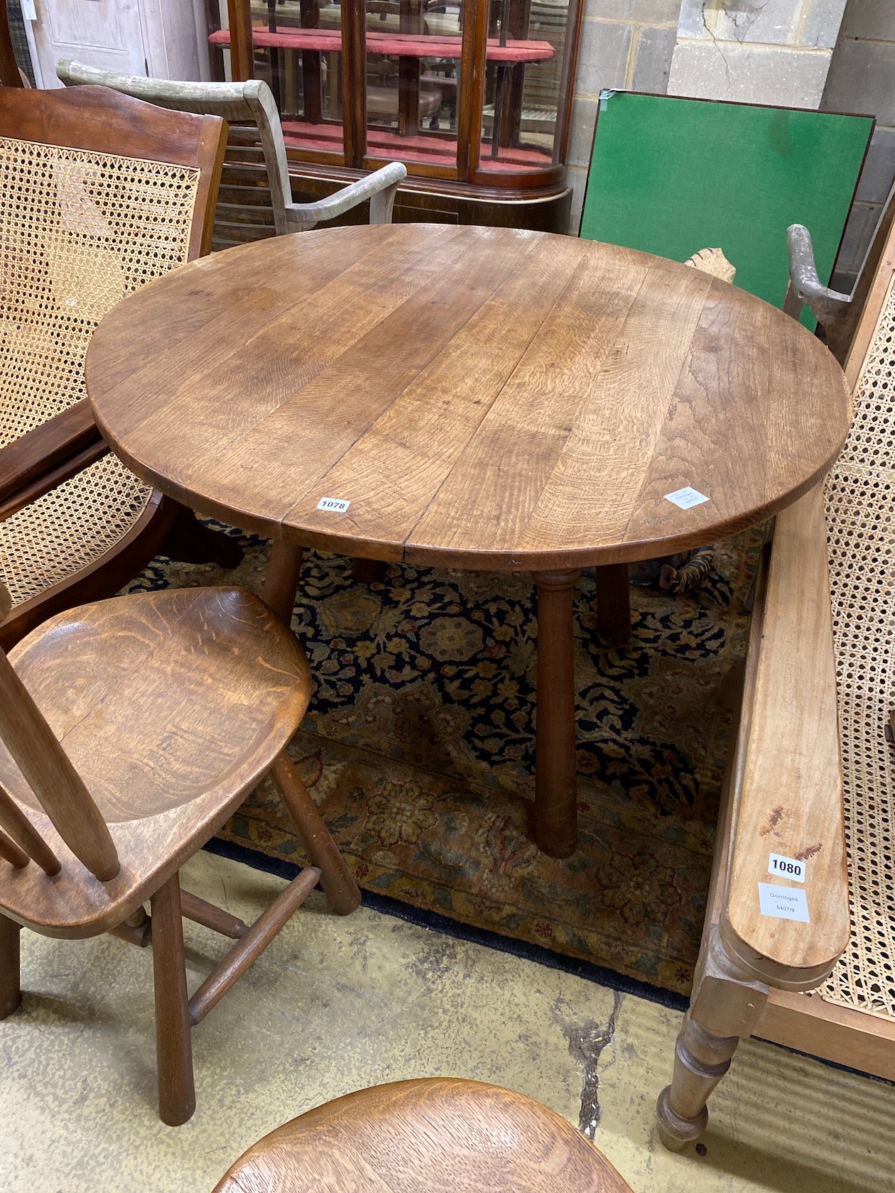 An Arts & Crafts style circular oak table, diameter 110cm, height 73cm and two chairs